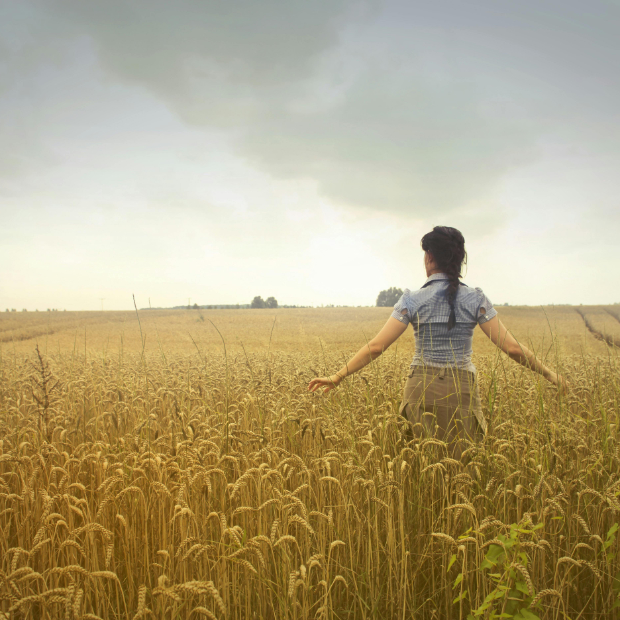 Woman in a field walking wistfully