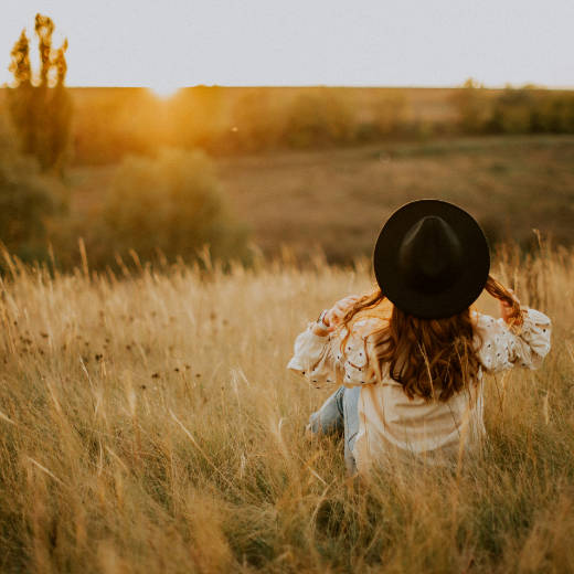 Trendy woman sitting in a field